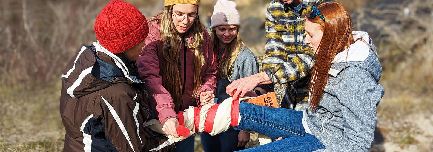 爱达荷州WWAMI的学生在医疗模拟中为一名志愿者受害者绑上了一个腿部支架.